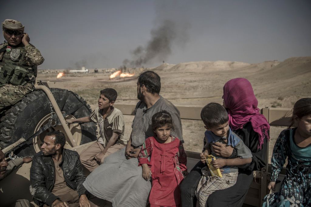 Fronten mot IS. I bergen utanför Mosul har kurdiska styrkorna, Persmerga, sin frontlinje mot IS. 12 män, kvinnor och barn som lyckats fly från en IS-kontrollerad by, de har tagit sig genom öknen och sökt skydd hos de kurdiska styrkorna. De förhörs och kontrolleras noga innan de förs vidare på ett lasbilsflak mot ytterligare förhör och senare till flyktingläger.
Foto: Magnus Wennman